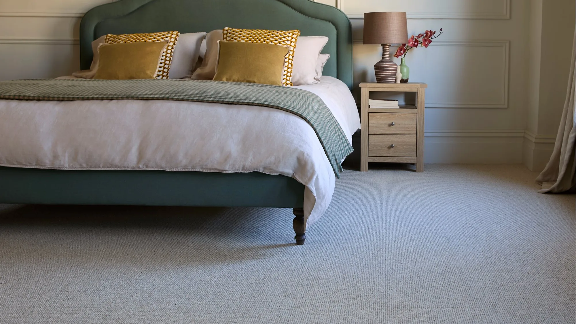 A bedroom finished with a pale wool carpet